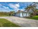 Side view of a charming light blue home featuring a large paved driveway at 8170 Casa De Meadows Dr, Englewood, FL 34224