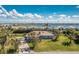 Beautiful one-story home with lush landscaping, palm trees, and a picturesque waterfront backdrop at 8170 Casa De Meadows Dr, Englewood, FL 34224