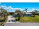 Beautiful single-story home featuring a lush, green lawn and mature palm trees at 8170 Casa De Meadows Dr, Englewood, FL 34224
