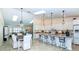 Open kitchen features island with breakfast bar, modern white cabinets, and stainless appliances at 8170 Casa De Meadows Dr, Englewood, FL 34224
