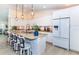 Modern kitchen features granite counters, white cabinets, stainless steel appliances, and island seating at 8170 Casa De Meadows Dr, Englewood, FL 34224