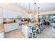 Open kitchen with granite island, pendant lighting, and outdoor patio access at 8170 Casa De Meadows Dr, Englewood, FL 34224