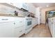 Modern kitchen featuring granite countertops, white cabinets, and stainless steel appliances at 8170 Casa De Meadows Dr, Englewood, FL 34224