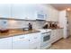 Contemporary kitchen featuring granite counters, stainless steel appliances and white cabinetry at 8170 Casa De Meadows Dr, Englewood, FL 34224