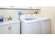 Laundry room features a sink with white cabinets and newer washer and dryer units at 8170 Casa De Meadows Dr, Englewood, FL 34224