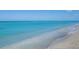 Calm ocean view with clear blue water meeting the sandy shore, ideal for a peaceful coastal experience at 8170 Casa De Meadows Dr, Englewood, FL 34224