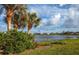 Scenic view of the pond, landscape, and community homes from the property's outdoor space at 8170 Casa De Meadows Dr, Englewood, FL 34224