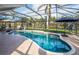 Sparkling pool and enclosed lanai are surrounded by lush tropical landscaping and mature palm trees at 8170 Casa De Meadows Dr, Englewood, FL 34224