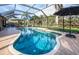 Sparkling screened-in pool surrounded by palm trees and lush landscaping at 8170 Casa De Meadows Dr, Englewood, FL 34224