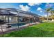 Backyard pool with lush greenery and a screened-in lanai offering a tropical oasis at 8170 Casa De Meadows Dr, Englewood, FL 34224