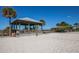 Sandy beach volleyball court with a wooden gazebo and clear blue sky at 8170 Casa De Meadows Dr, Englewood, FL 34224