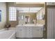 Bathroom with a large mirror, double sinks, and ample lighting exudes modern comfort and style at 902 Tartan Dr # 29, Venice, FL 34293