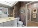 Stylish bathroom featuring a white vanity and toilet, shower, and dramatic floral wallpaper at 902 Tartan Dr # 29, Venice, FL 34293
