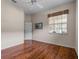Neutral bedroom with hardwood floors, a ceiling fan, and a large window letting in lots of natural light at 902 Tartan Dr # 29, Venice, FL 34293