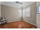Bright bedroom featuring hardwood floors, a ceiling fan, and two windows with plantation shutters at 902 Tartan Dr # 29, Venice, FL 34293