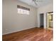 Well-lit bedroom showcasing wood floors, window with blinds, and easy access to the ensuite bathroom at 902 Tartan Dr # 29, Venice, FL 34293