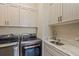 Well-equipped laundry room with modern washer, dryer, granite counters, stainless sink and ample cabinet space at 902 Tartan Dr # 29, Venice, FL 34293