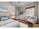 Well-lit main bedroom featuring wood floors, light colored walls, ceiling fan, and an accent chair at 902 Tartan Dr # 29, Venice, FL 34293