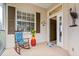 Cozy front porch with a rocking chair, small table, and views of the landscaped yard at 902 Tartan Dr # 29, Venice, FL 34293