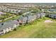 Aerial view of community condos with green roofs near a tennis court and golf course with pond at 903 Gondola Park Dr # 903, Venice, FL 34292