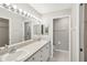 A bathroom with double sinks and a large mirror illuminated by a modern light fixture at 903 Gondola Park Dr # 903, Venice, FL 34292