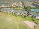 Aerial view of condominium complex with green roofs, screened lanais, set on a golf course near a tennis court at 903 Gondola Park Dr # 903, Venice, FL 34292