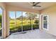 Screened lanai overlooking a golf course with stone tile flooring and a ceiling fan at 903 Gondola Park Dr # 903, Venice, FL 34292