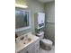 Bathroom with a single sink vanity, a toilet and cabinet, and a framed mirror at 919 Cortina Blvd, Venice, FL 34285