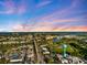 A scenic aerial view showcases the city, coastline, and canals meeting the ocean under a colorful sky at 944 Capri Isles Blvd # 103, Venice, FL 34292