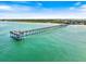 Expansive aerial view of the turquoise ocean, sandy beach, and long pier extending into the water at 944 Capri Isles Blvd # 103, Venice, FL 34292