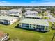 Aerial view of a two-story condo building with grassy lawn area, trees and sidewalks at 944 Capri Isles Blvd # 103, Venice, FL 34292