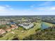 A high angle showcases the golf community featuring lush greenery, serene lakes, and a green pushpin at 944 Capri Isles Blvd # 103, Venice, FL 34292