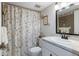 Cozy bathroom featuring a shower with seashell patterned shower curtain and vanity with sink and mirror at 944 Capri Isles Blvd # 103, Venice, FL 34292