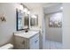 Well-lit bathroom with a single sink vanity, decorative starfish, and a doorway leading to another room at 944 Capri Isles Blvd # 103, Venice, FL 34292
