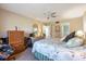 A well-lit bedroom featuring a ceiling fan and natural wood furniture at 944 Capri Isles Blvd # 103, Venice, FL 34292