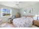 Bedroom featuring floral bedding, recliner, ceiling fan, and a bright window at 944 Capri Isles Blvd # 103, Venice, FL 34292