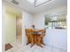 Cozy dining area with tile flooring, wooden table and chairs, and a passthrough to living room at 944 Capri Isles Blvd # 103, Venice, FL 34292