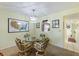 Dining area with a decorative glass table, rattan chairs, and a view into the kitchen at 944 Capri Isles Blvd # 103, Venice, FL 34292