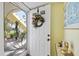 Welcoming condo entrance with decorative wreath, golf-themed door, and view of the outdoor patio at 944 Capri Isles Blvd # 103, Venice, FL 34292