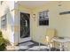 Charming condo entrance with a decorative door and a cozy outdoor seating area at 944 Capri Isles Blvd # 103, Venice, FL 34292