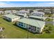 Aerial view of the condo building with a large grassy yard and ample parking at 944 Capri Isles Blvd # 103, Venice, FL 34292