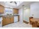Bright kitchen with wood cabinets, a white dishwasher, and a window with natural light at 944 Capri Isles Blvd # 103, Venice, FL 34292