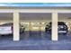 Covered parking area with two parked cars, offering protection from the elements and convenient access at 944 Capri Isles Blvd # 103, Venice, FL 34292