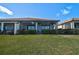 View of the screened-in lanai with a lush green lawn under a bright blue sky at 9900 Haze Dr, Venice, FL 34292