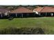 Expansive backyard with lush grass and a screened lanai, backing up to a serene pond at 9900 Haze Dr, Venice, FL 34292