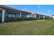 Lush backyard with green grass and low shrubs, offering privacy and a serene outdoor space at 9900 Haze Dr, Venice, FL 34292