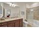 Bright bathroom featuring granite counters, a large mirror, and tiled shower with glass door at 9900 Haze Dr, Venice, FL 34292