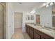 Elegant bathroom with dual sinks, granite countertops, and a walk-in closet at 9900 Haze Dr, Venice, FL 34292