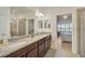 Well-lit bathroom with granite countertops, dual sinks, and a seamless glass shower at 9900 Haze Dr, Venice, FL 34292