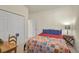 Bedroom features a comfortable bed, a wooden desk, and a closet for storage at 9900 Haze Dr, Venice, FL 34292